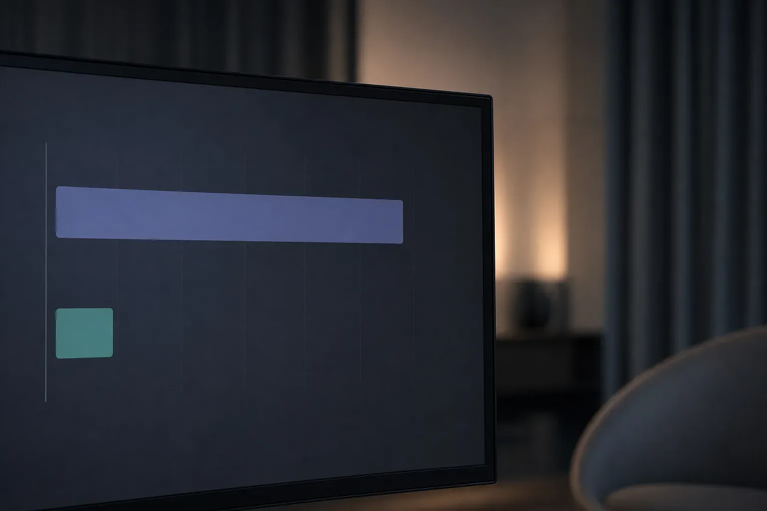 A monitor in a dimly lit room displays two soft colour bars, a wide blue-purple rectangle and a smaller teal square, on a dark screen